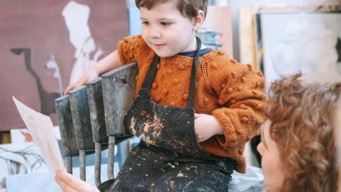 a boy looking at his artwork